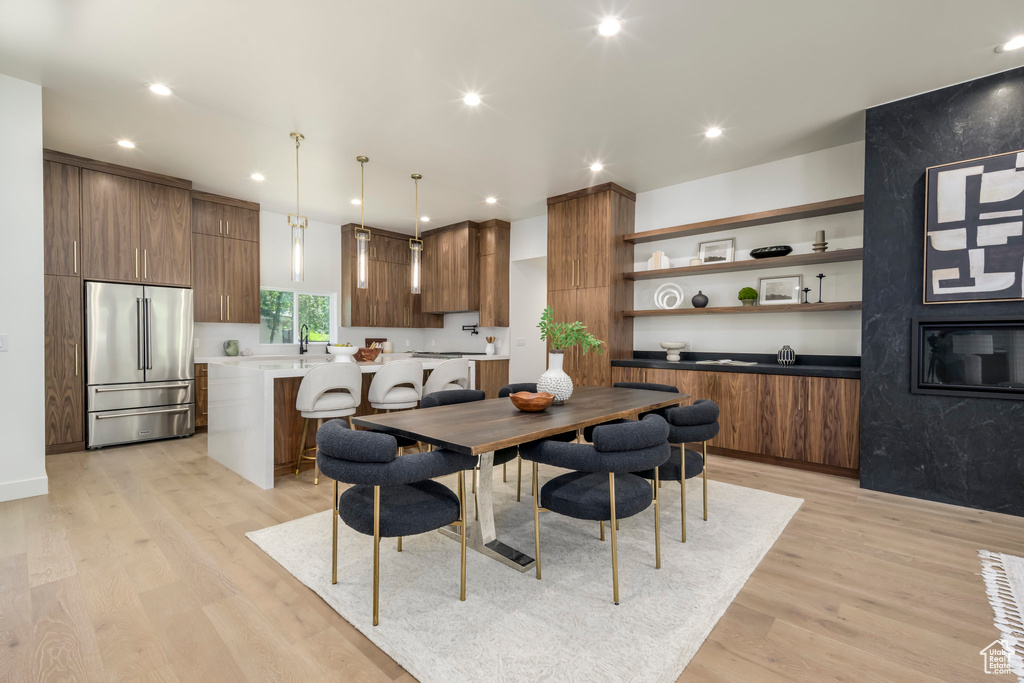 Dining room with light wood-type flooring and recessed lighting