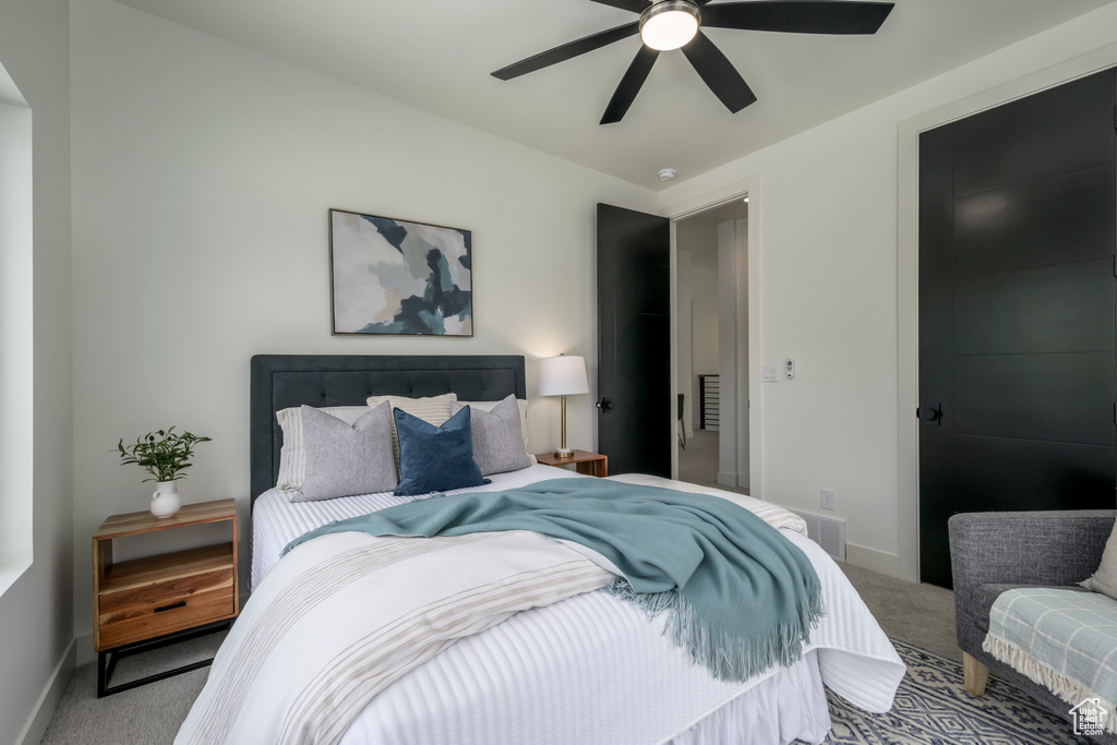 Carpeted bedroom featuring baseboards and ceiling fan