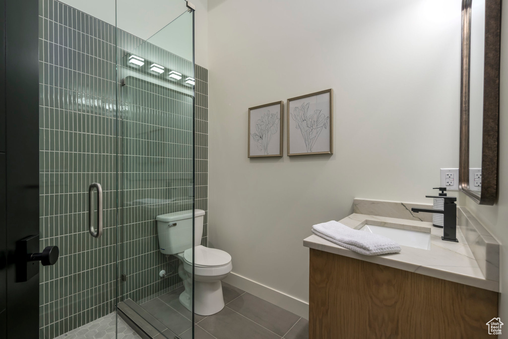 Bathroom with vanity, a tile shower, and tile patterned floors