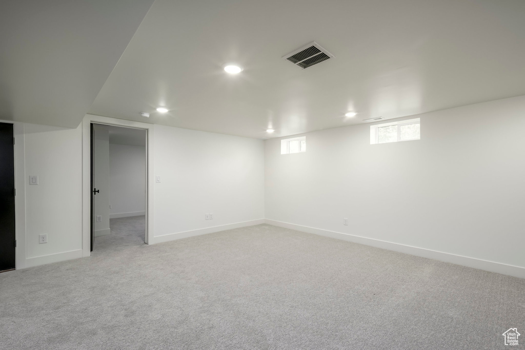 Below grade area featuring recessed lighting and light carpet