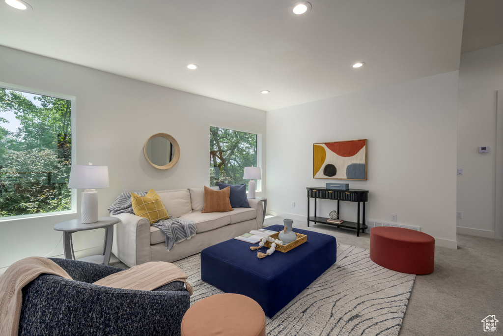 Carpeted living area with healthy amount of natural light and recessed lighting