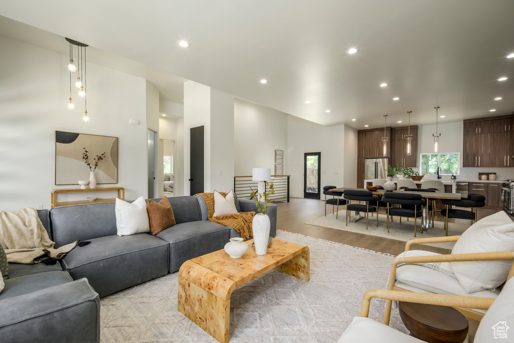 Living area with light wood finished floors and recessed lighting