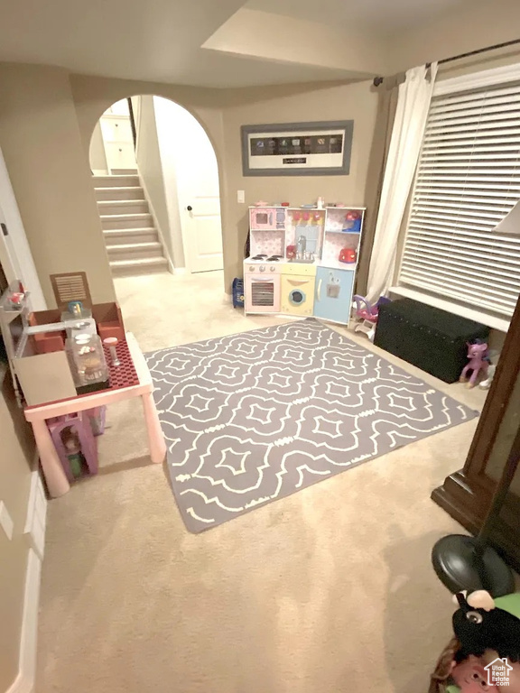 Playroom with carpet flooring and arched walkways