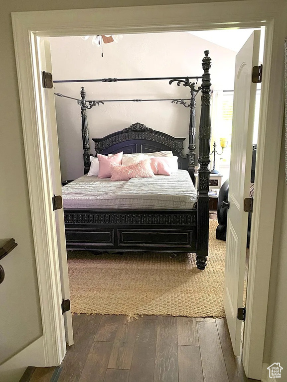 Bedroom with dark wood-style flooring and lofted ceiling