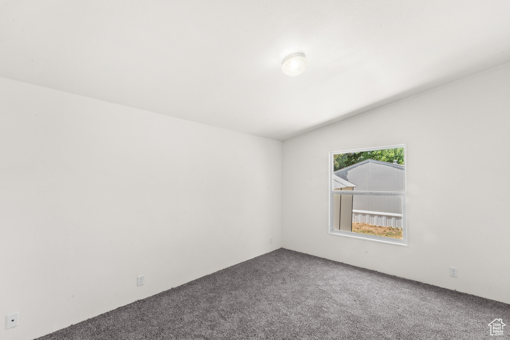 Carpeted spare room with lofted ceiling