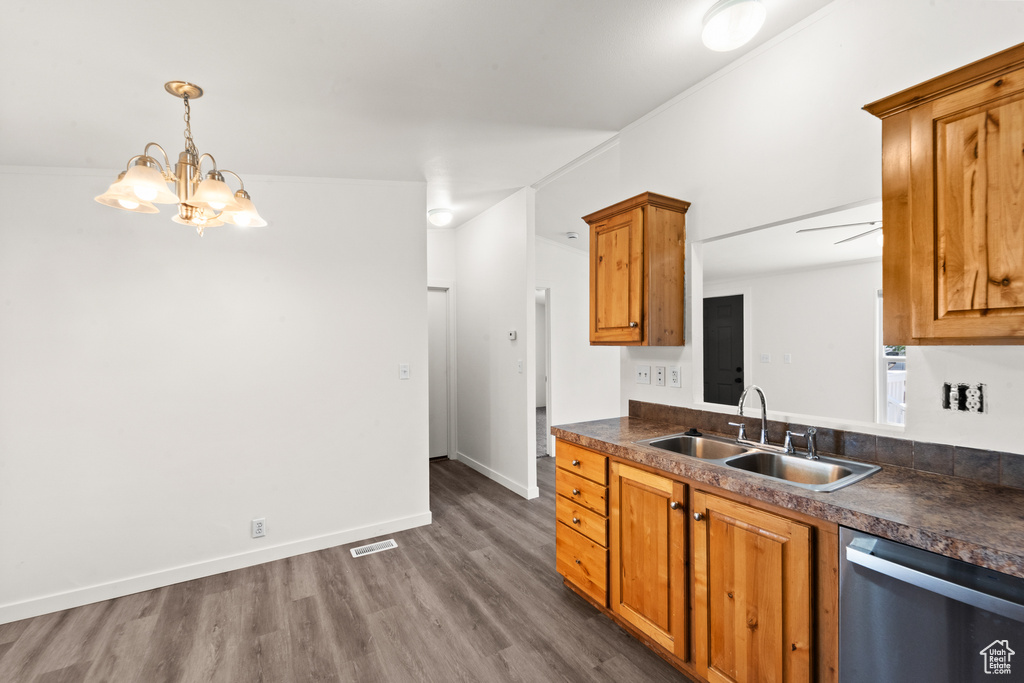 Kitchen with dishwasher, dark wood-style floors, dark countertops, and brown cabinets