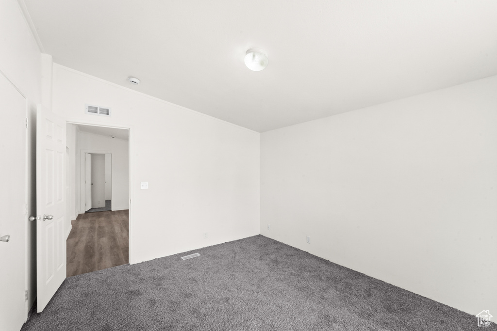 Unfurnished room featuring carpet flooring, a smoke detector, and crown molding