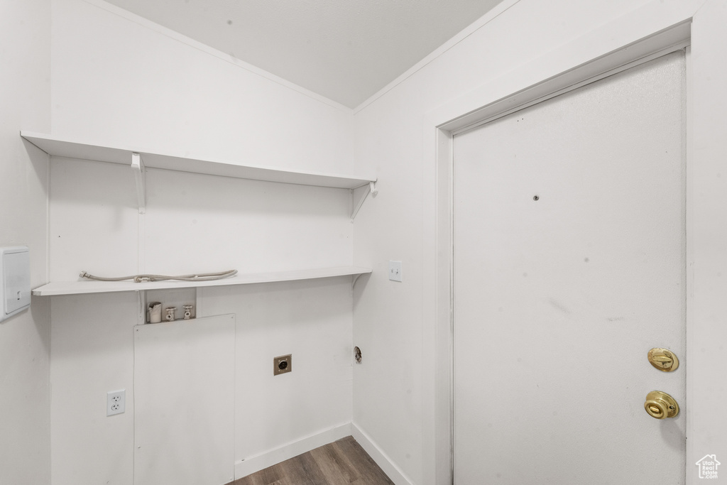 Washroom with hookup for an electric dryer, hookup for a washing machine, wood finished floors, and ornamental molding