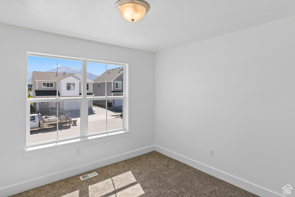 Carpeted spare room with baseboards