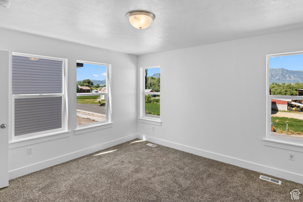 Carpeted empty room featuring baseboards