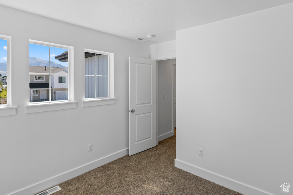 Carpeted spare room with baseboards