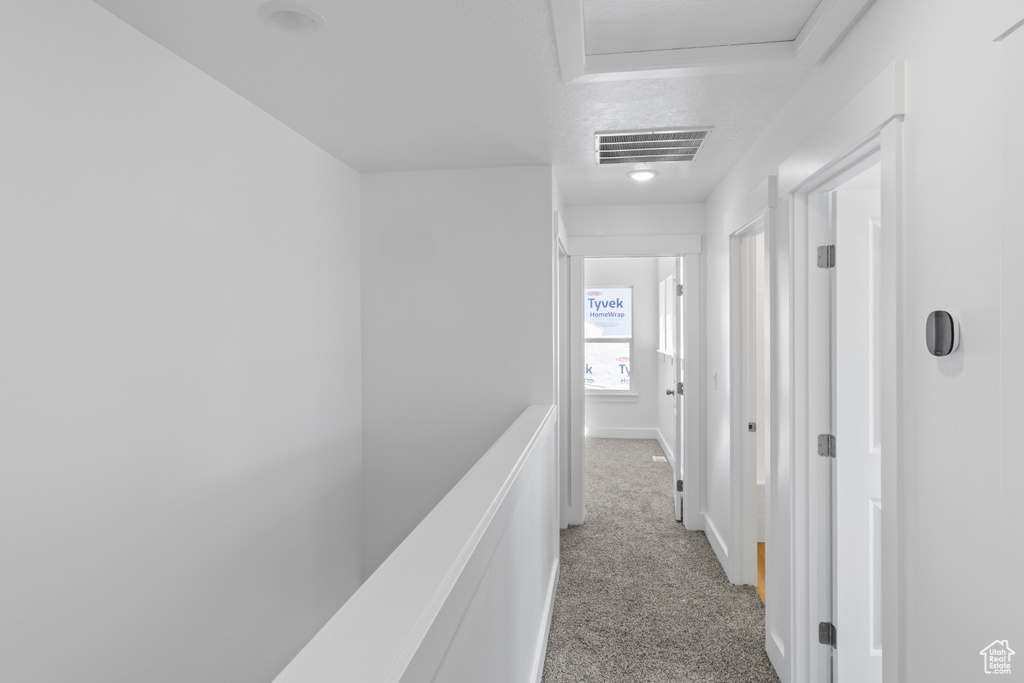 Hallway with carpet and attic access