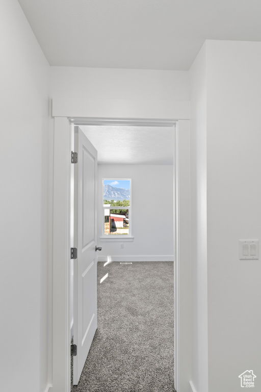 Hall featuring carpet and baseboards