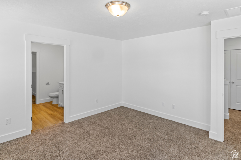 Unfurnished bedroom featuring carpet floors and ensuite bathroom