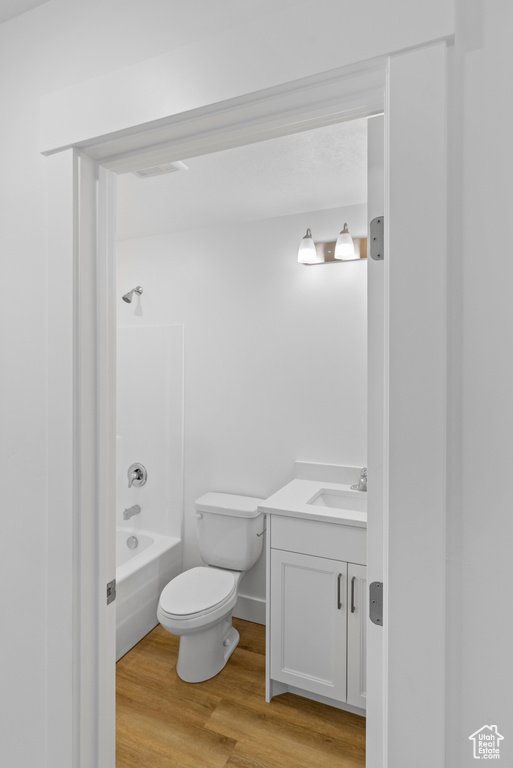 Full bathroom with vanity, shower / tub combination, and wood finished floors