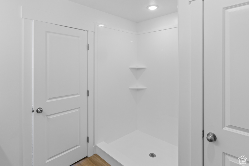 Full bath featuring a shower stall and wood finished floors