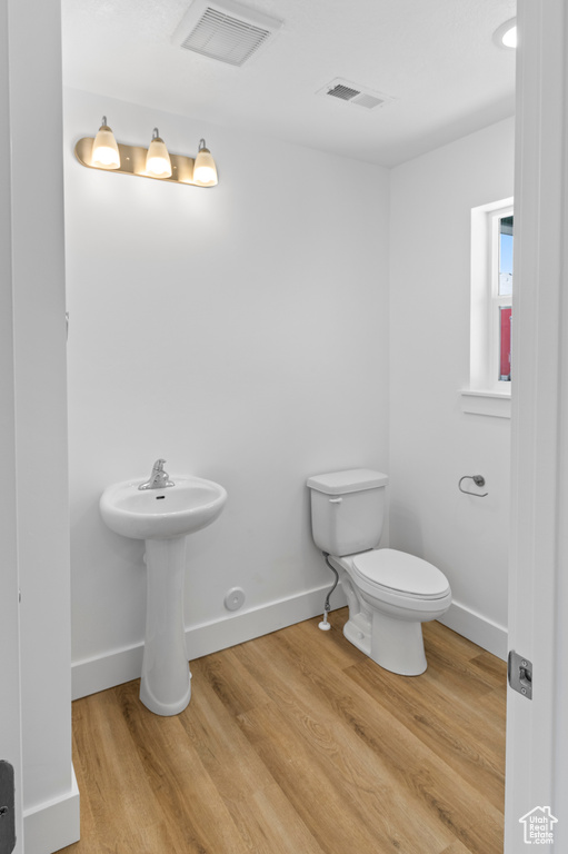 Bathroom featuring toilet and wood finished floors