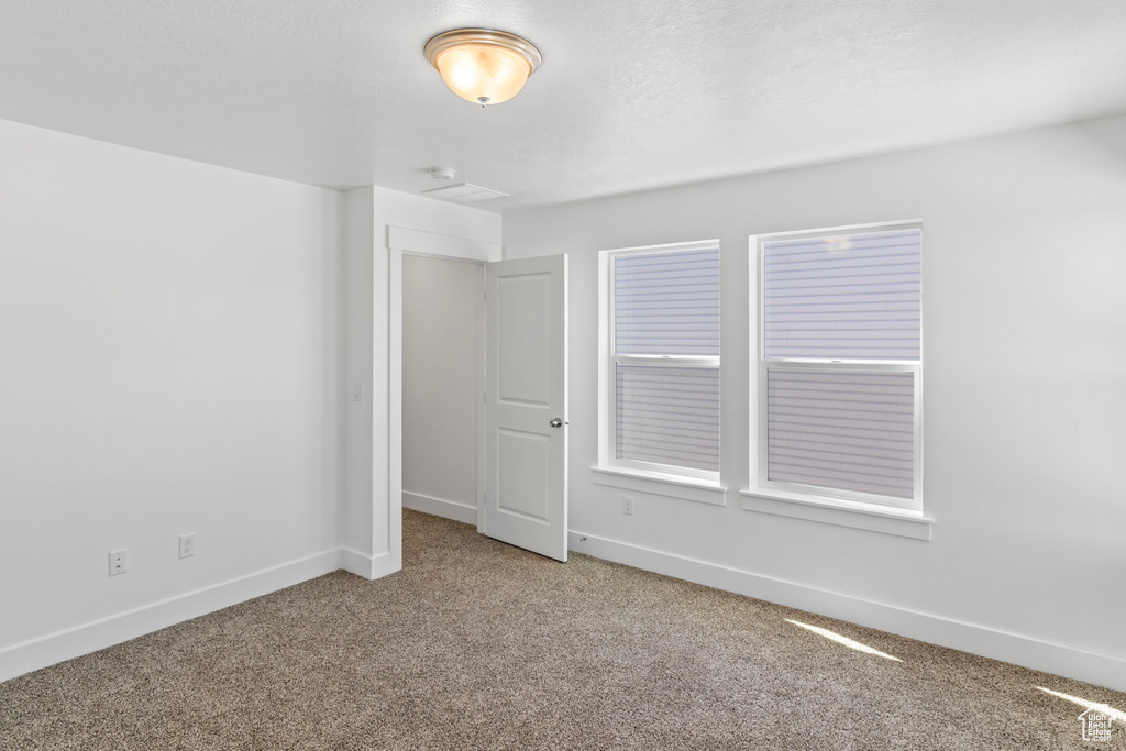Unfurnished room featuring carpet floors and baseboards