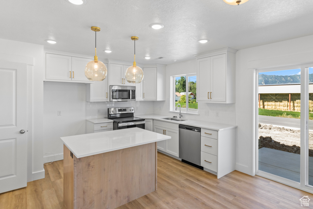 Kitchen featuring stainless steel appliances, tasteful backsplash, plenty of natural light, white cabinets, and recessed lighting