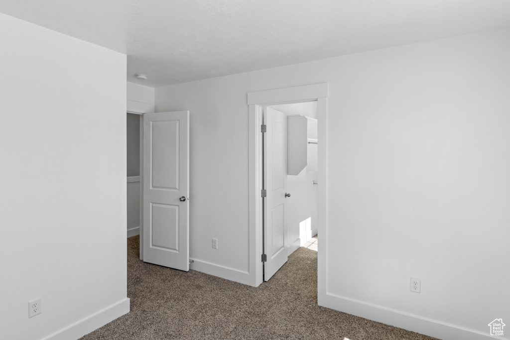 Unfurnished bedroom featuring carpet flooring and baseboards