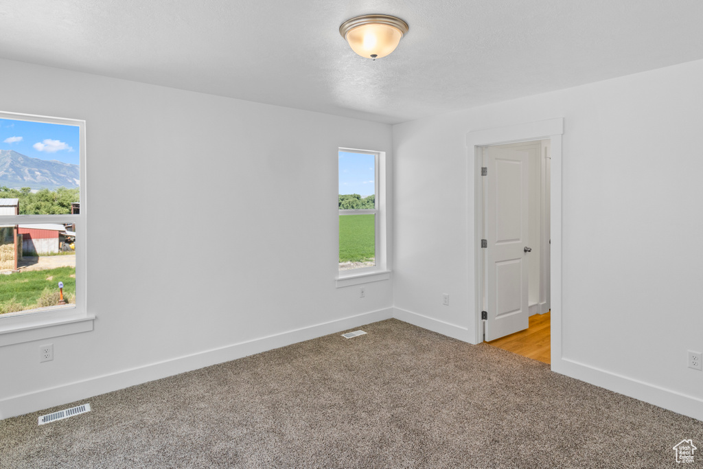 Carpeted spare room with baseboards