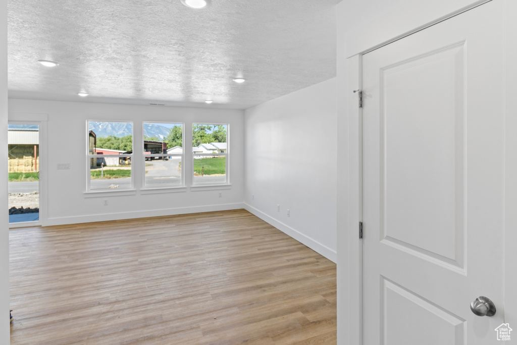 Spare room featuring a textured ceiling and light wood-style flooring