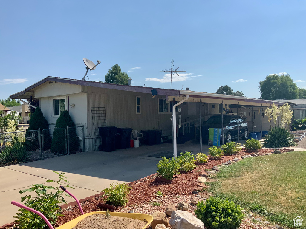 Back of property with a carport and driveway