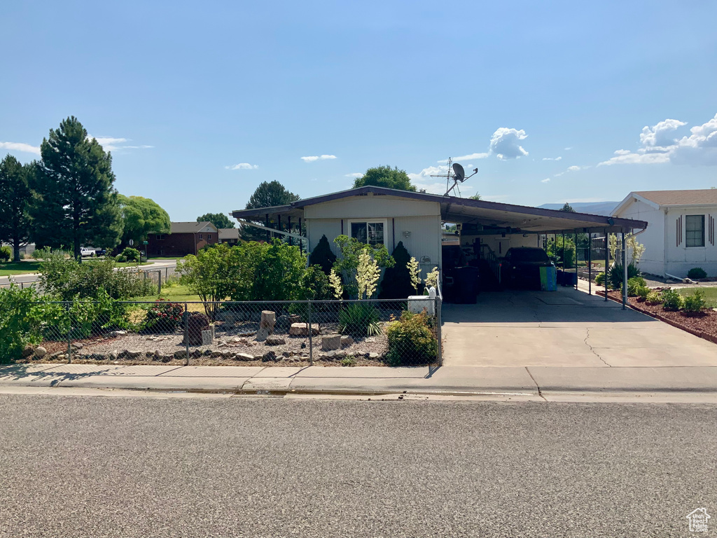 View of front of house featuring an attached carport and driveway