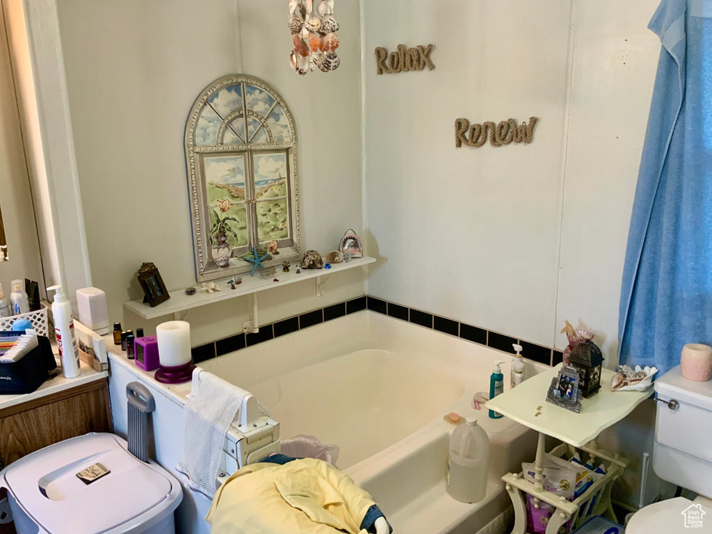 Full bathroom featuring toilet and a garden tub