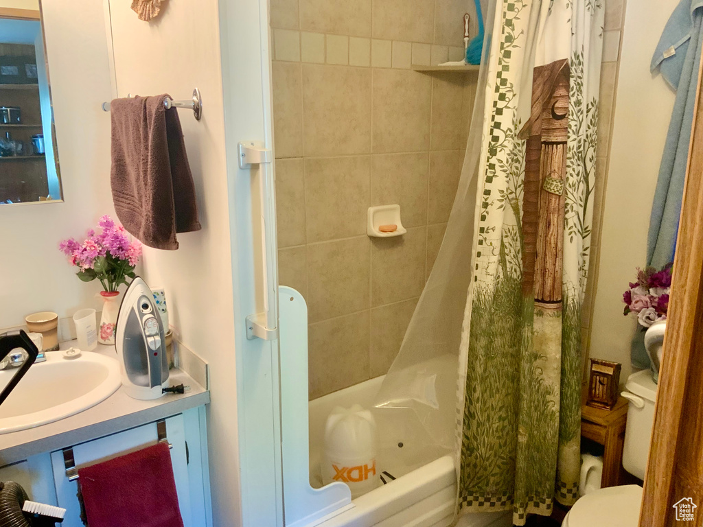 Bathroom featuring shower / bath combo with shower curtain and vanity