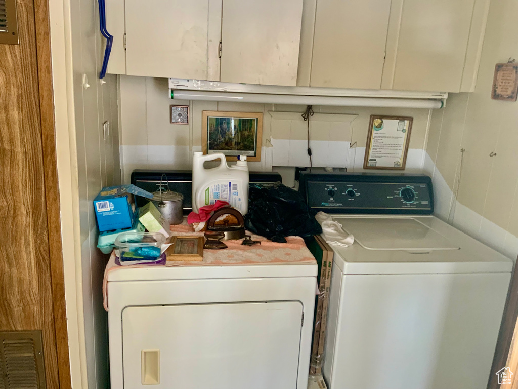 Washroom with washing machine and clothes dryer and cabinet space