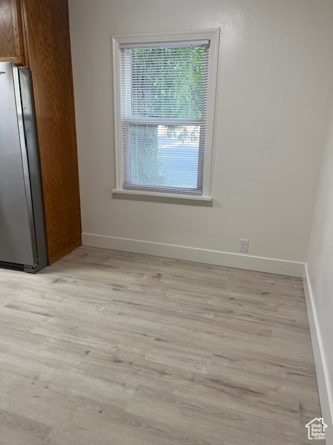 Unfurnished dining area with light wood-style flooring and baseboards