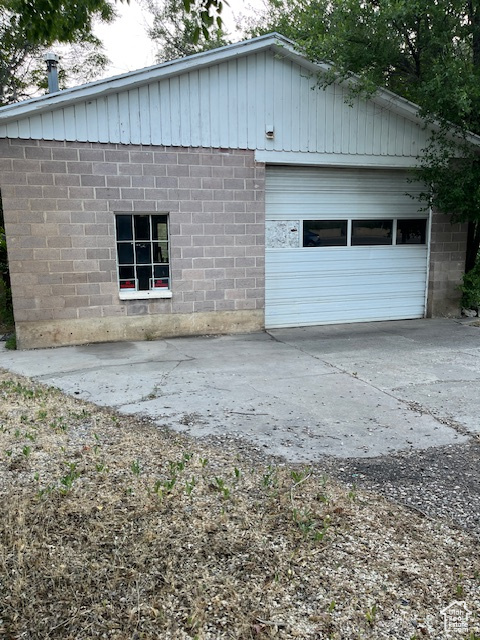 View of side of property featuring concrete driveway and concrete block siding