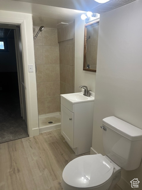 Full bath featuring wood finished floors, vanity, and a shower stall