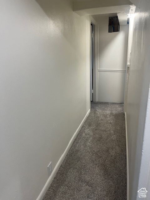 Hall with carpet flooring and baseboards
