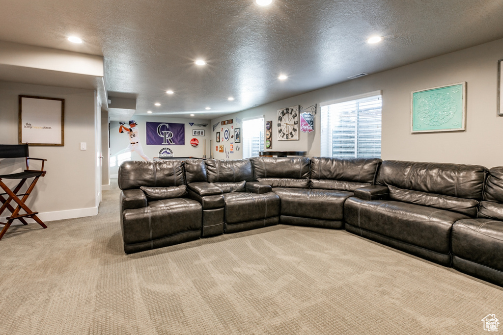 Living area featuring recessed lighting, light colored carpet, and a textured ceiling
