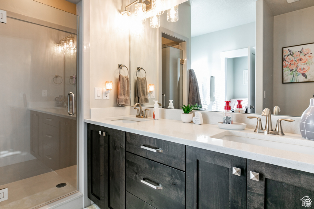 Full bath with double vanity and a shower stall