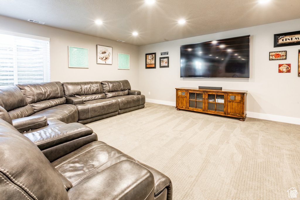 Carpeted living area with baseboards and recessed lighting