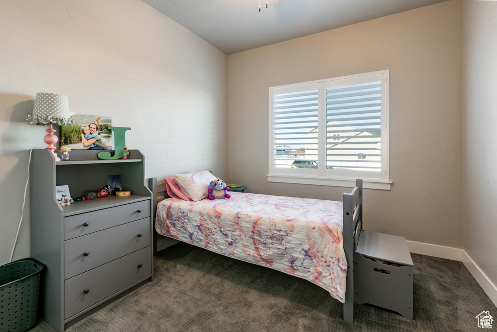 Bedroom featuring carpet and baseboards