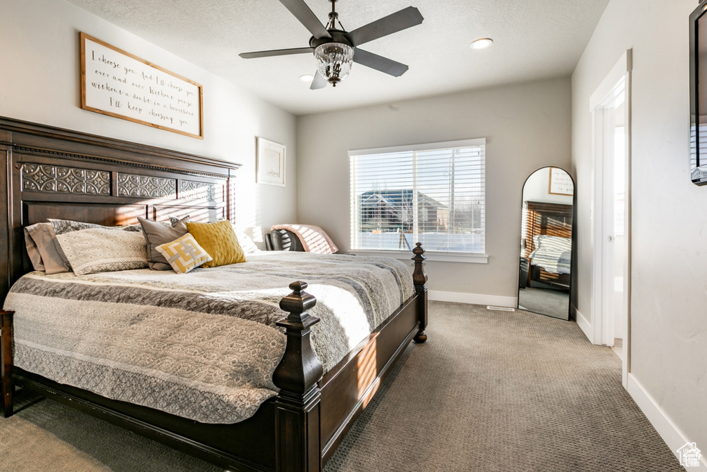 Carpeted bedroom with baseboards and a ceiling fan