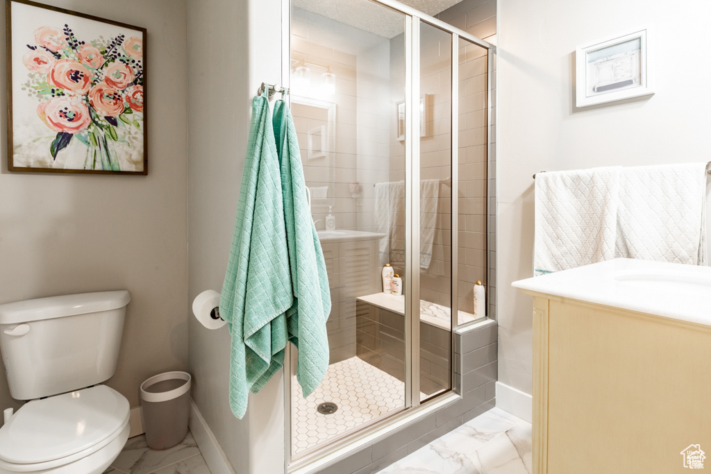 Full bath featuring marble finish flooring, vanity, and a stall shower