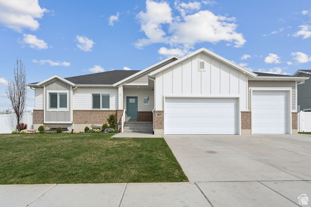 View of front facade with brick siding, a garage, board and batten siding, and concrete driveway