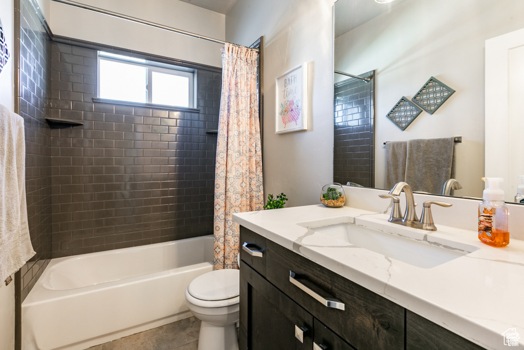 Full bathroom with vanity, shower / tub combo with curtain, and tile patterned floors