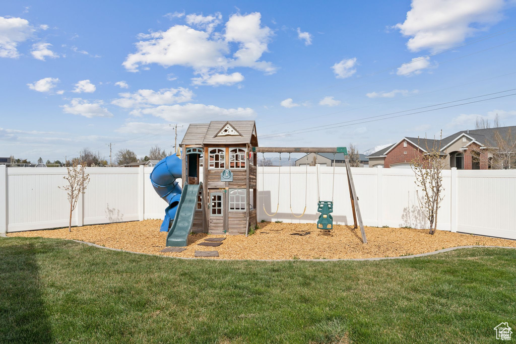 View of jungle gym with a fenced backyard