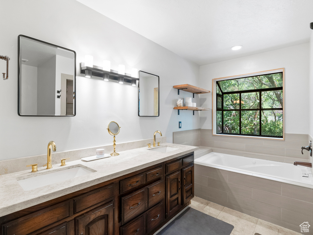 Full bathroom featuring double vanity, a bath, and tile patterned flooring