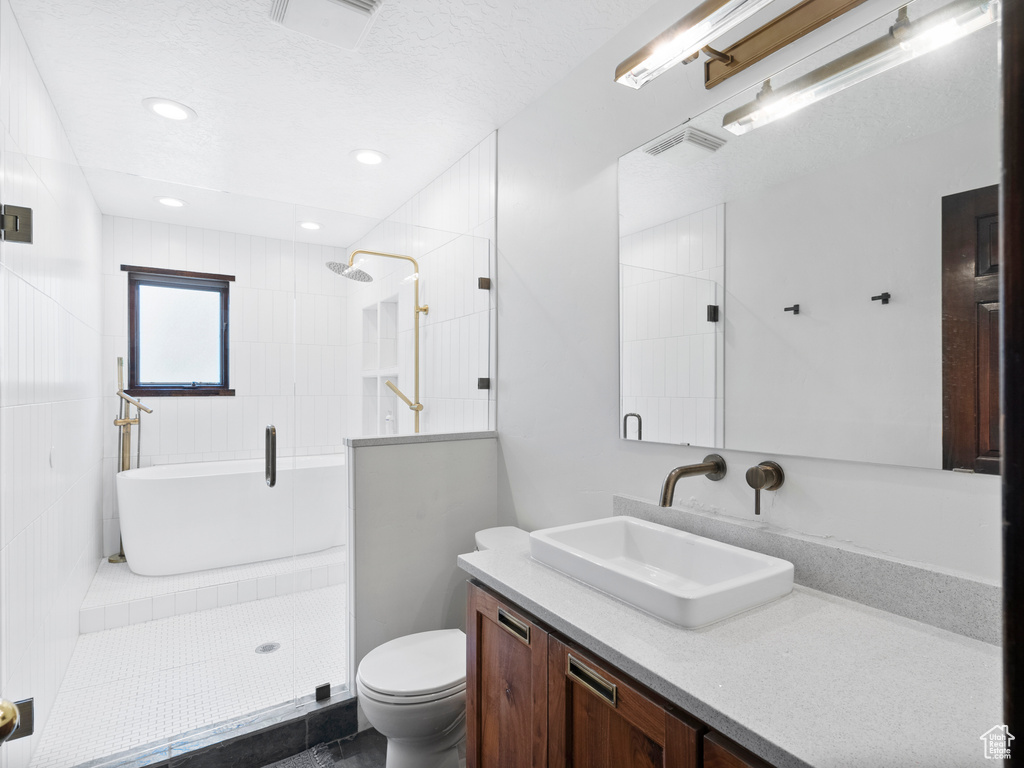 Full bath featuring vanity, a tile shower, and recessed lighting