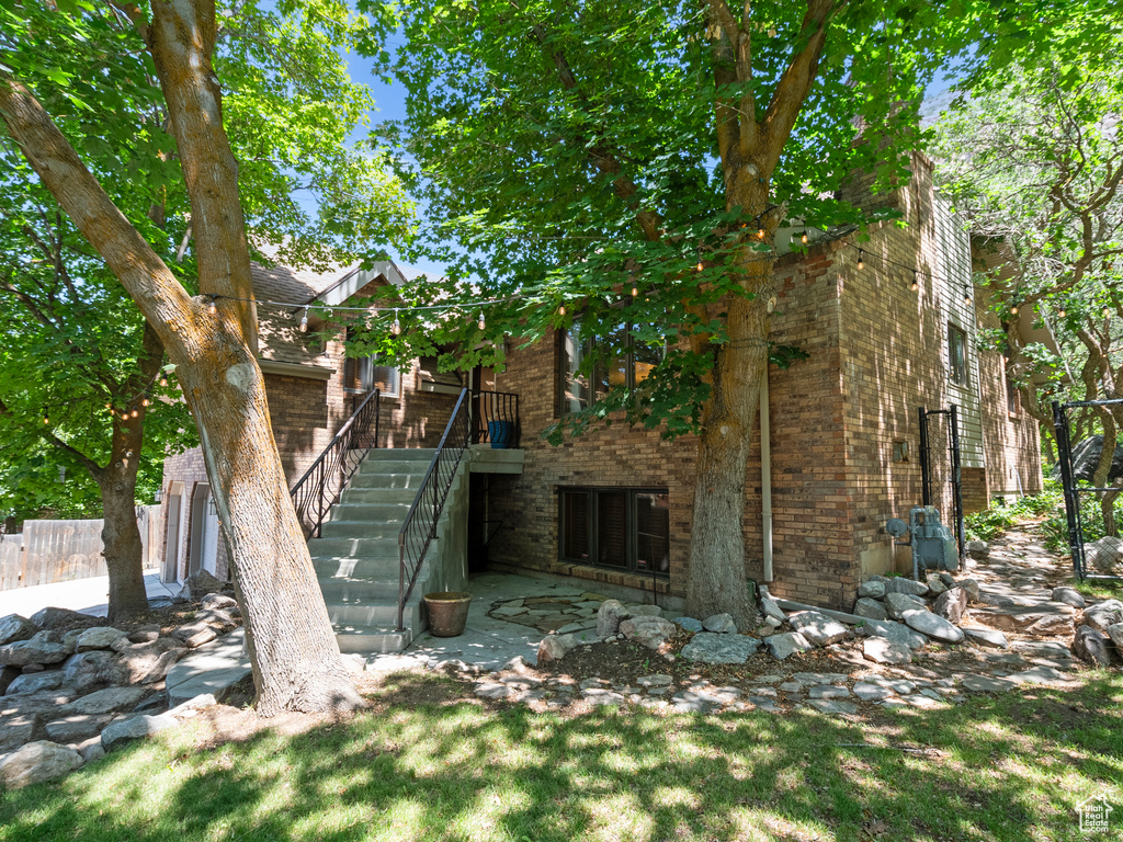 Rear view of property featuring brick siding and stairs