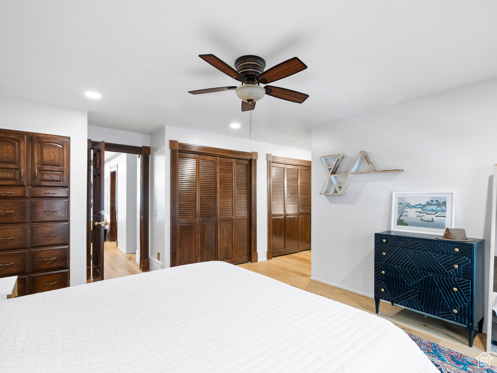 Bedroom featuring recessed lighting, light wood finished floors, two closets, and a ceiling fan
