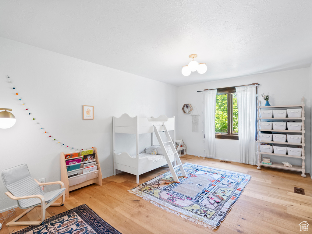Bedroom with light wood-style flooring and a chandelier