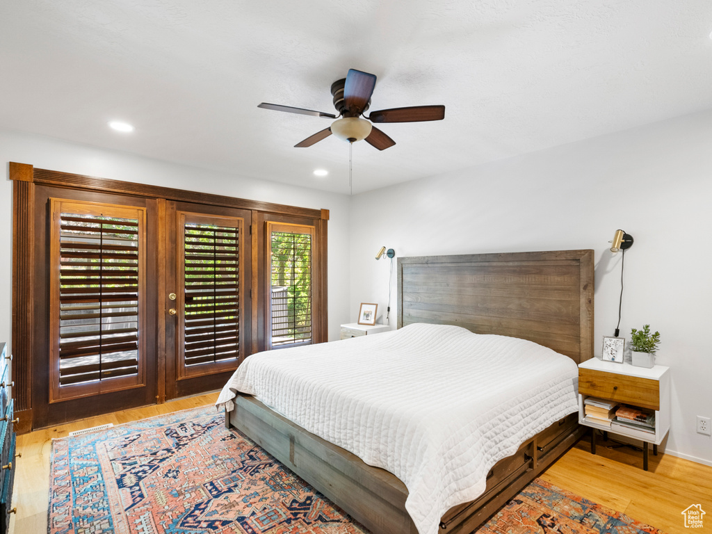 Bedroom with access to outside, light wood finished floors, ceiling fan, and recessed lighting